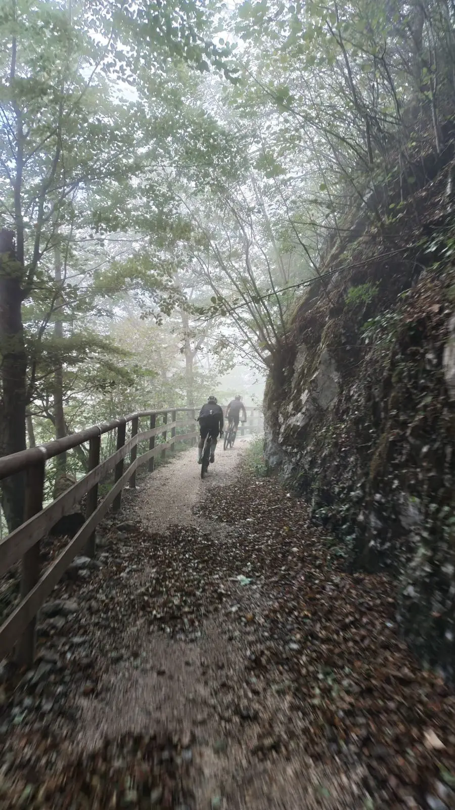 Im Nebel zurück nach Inzell: Schotterweg mit Holzgeländer, direkt an der Felswand entlang.