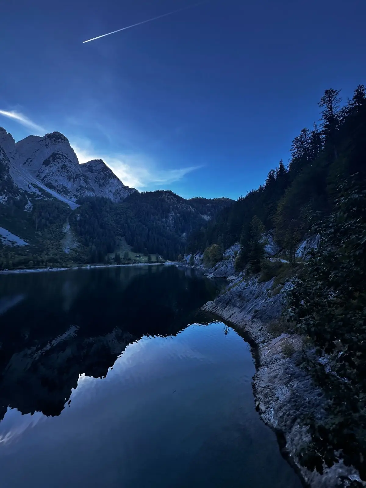 Blaue Stunde am Gosausee: Die Felswände spiegeln sich im Wasser.