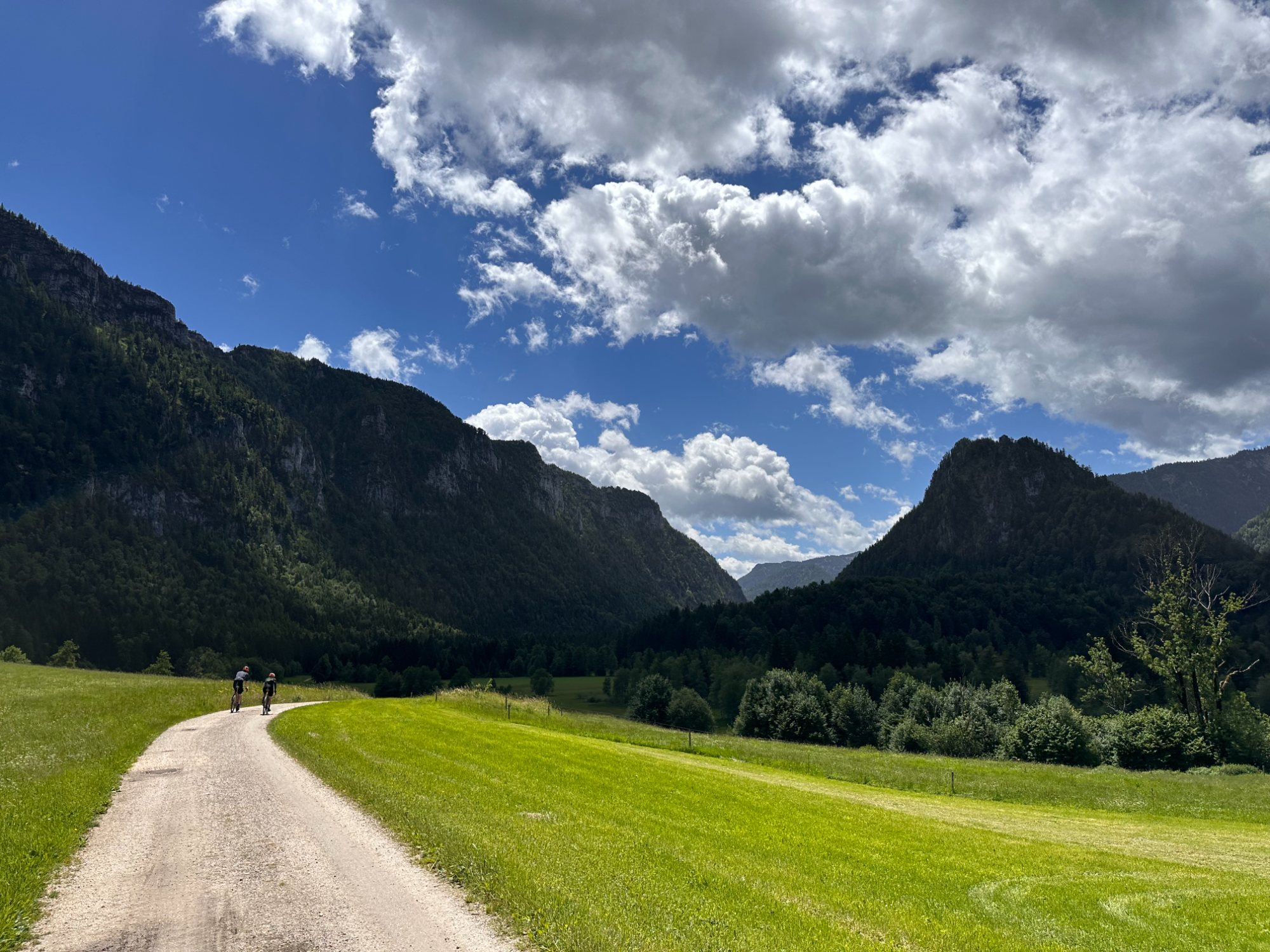Feiner Schotter durchs weite Talinnere — Wolkenkino über den Chiemgauer Bergen.